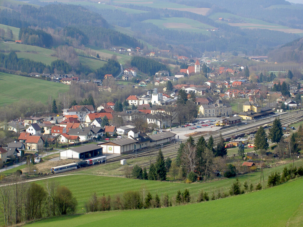 Ein bereits höher auflösendes Foto der digitalen Fotografie mit Blick von einem Hügel auf den Bahnhof meines Heimatortes Aspang am Wechsel. Hinter dem Bahnhof Unteraspang und Richtung Pittental.