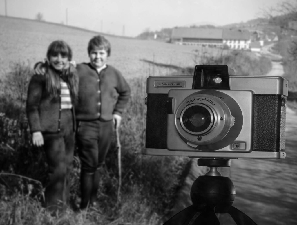 Ein schwarz/weiß Foto von der Revue Junior. Im Hintergrund leicht verschwommen ein Bild von meiner Schwester und mir beim Wandern.